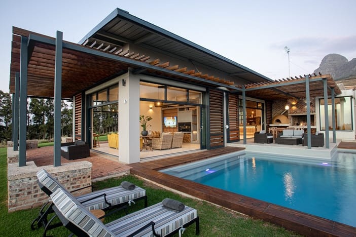 Taaibosch Wine Estate now offers luxury accommodation in the Cape Winelands 2 A swimming pool outside a house
Description automatically generated with low confidence